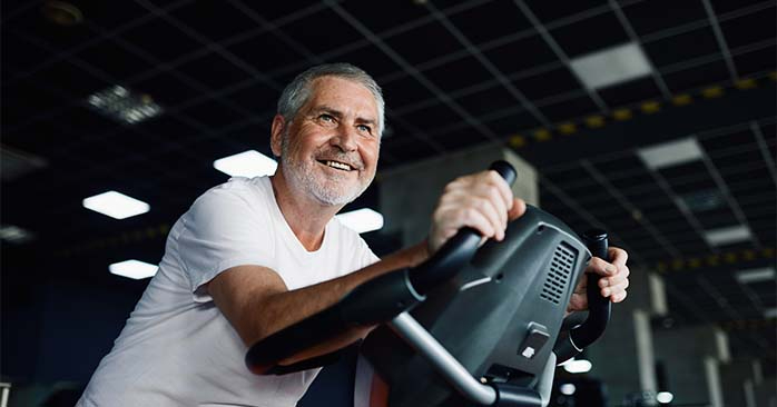 Man on exercise bike smiling.